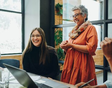 Two women at a meeting laughing