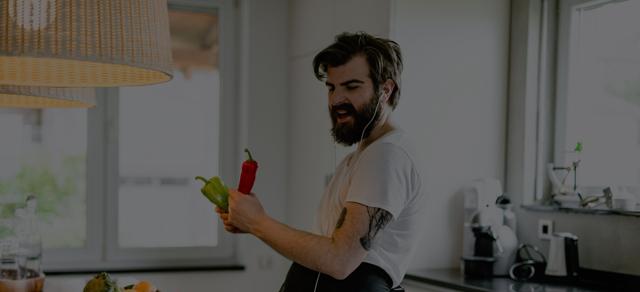 Man listening to music and singing while cooking healthy food